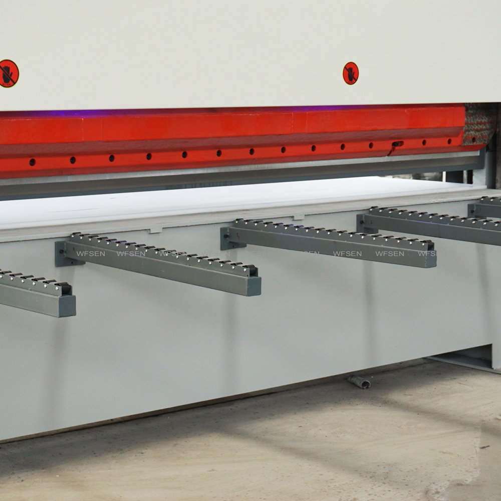 Outfeed support arms with rollers on a WFSEN veneer clipper, carrying cut veneer clear of the knife
