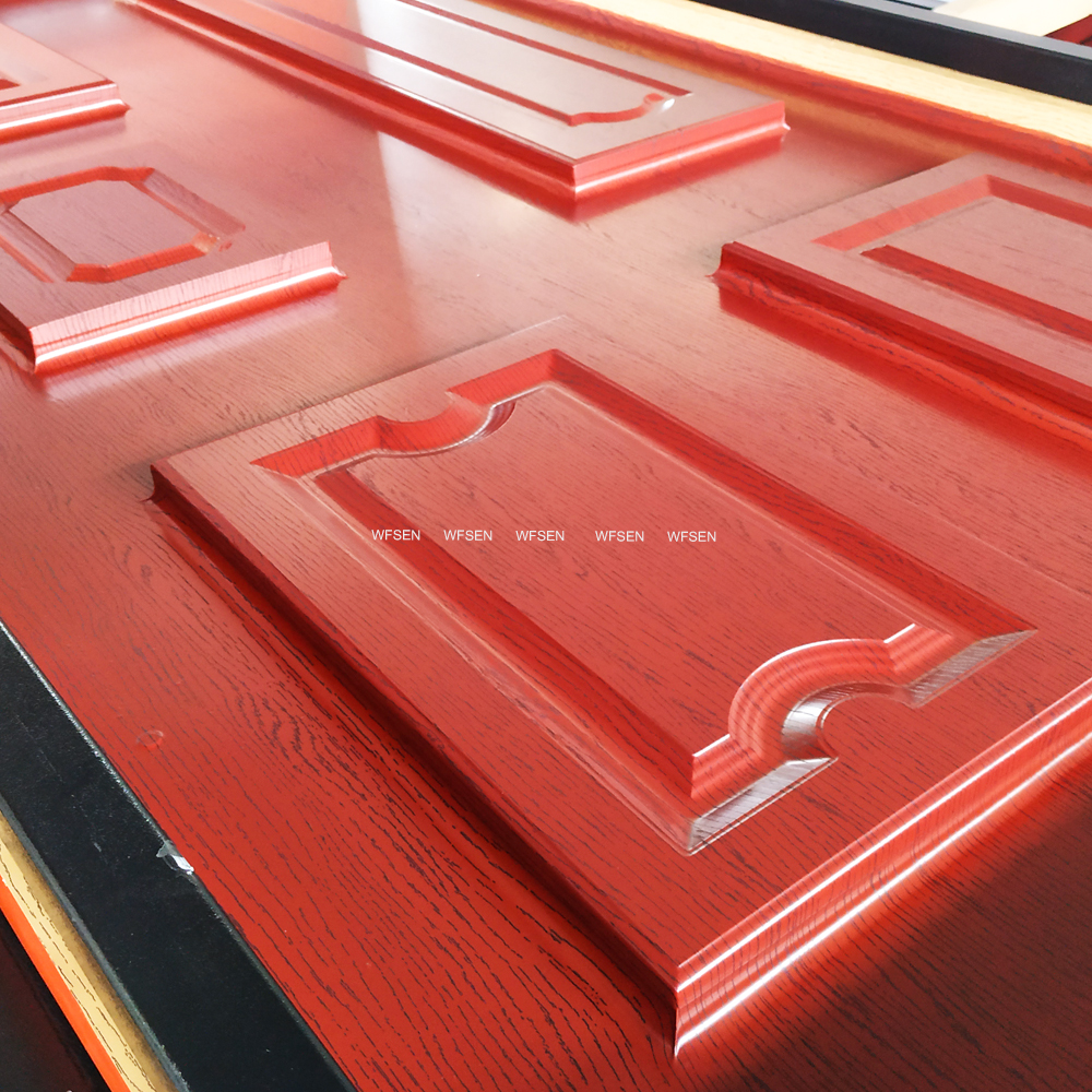 Raised panel doors laminated with red PVC film on a WFSEN vacuum membrane press, showing the film wrapped into the moulded profiles